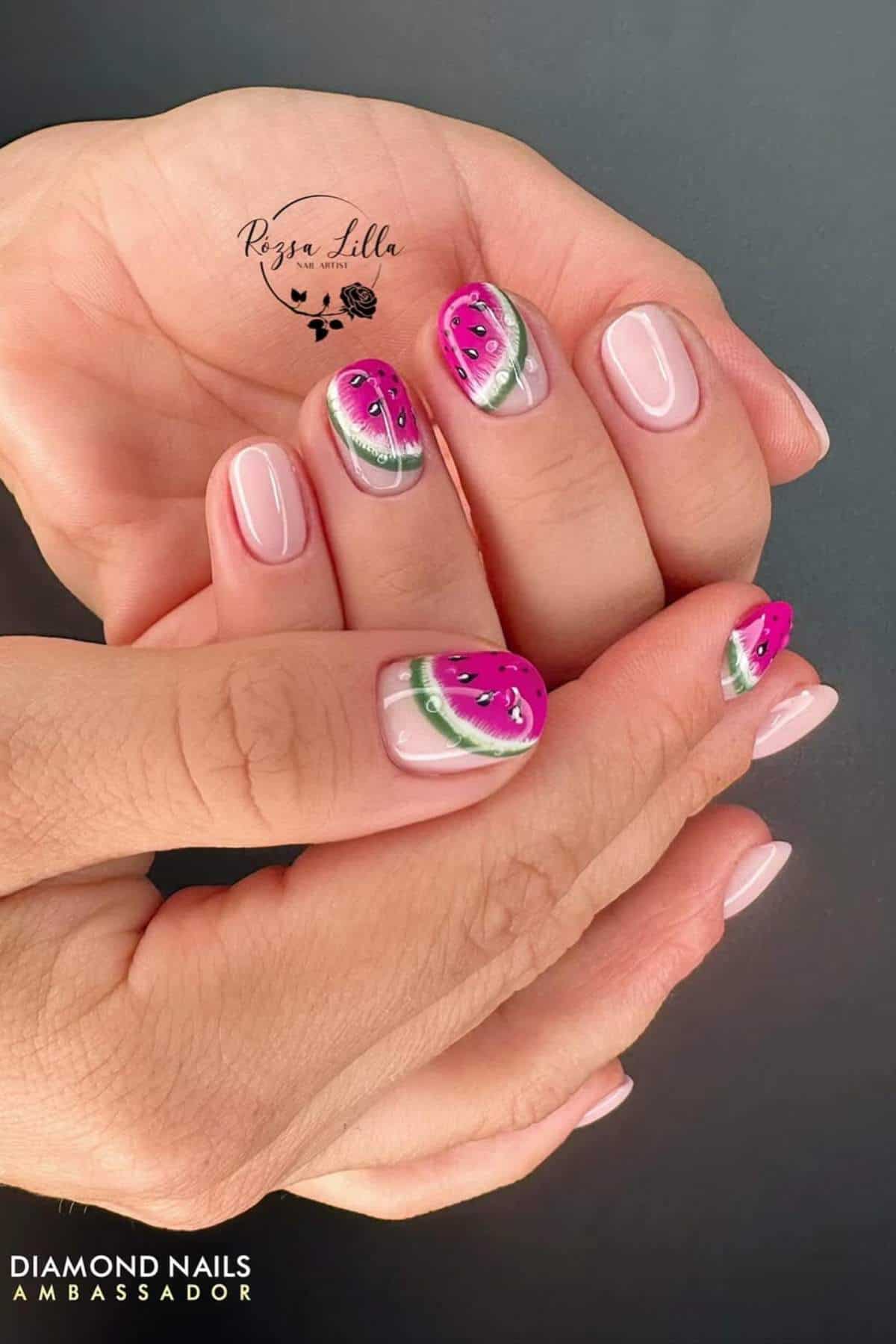 Hands with manicured nails featuring a watermelon design on some nails and a nude, glossy finish on others.