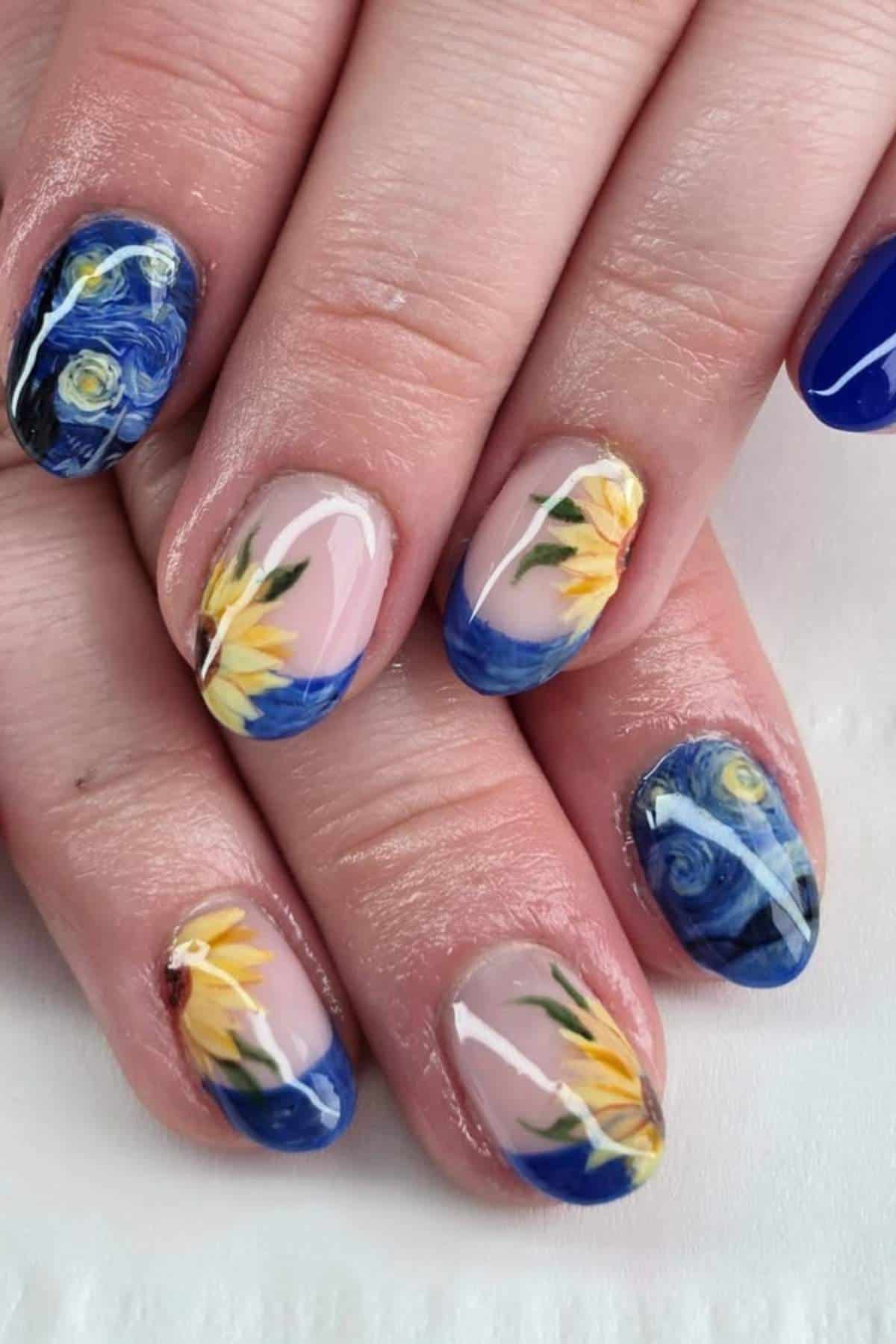 Close-up of fingernails painted with designs inspired by sunflowers and Van Gogh's "Starry Night" in blue, yellow, and natural tones.
