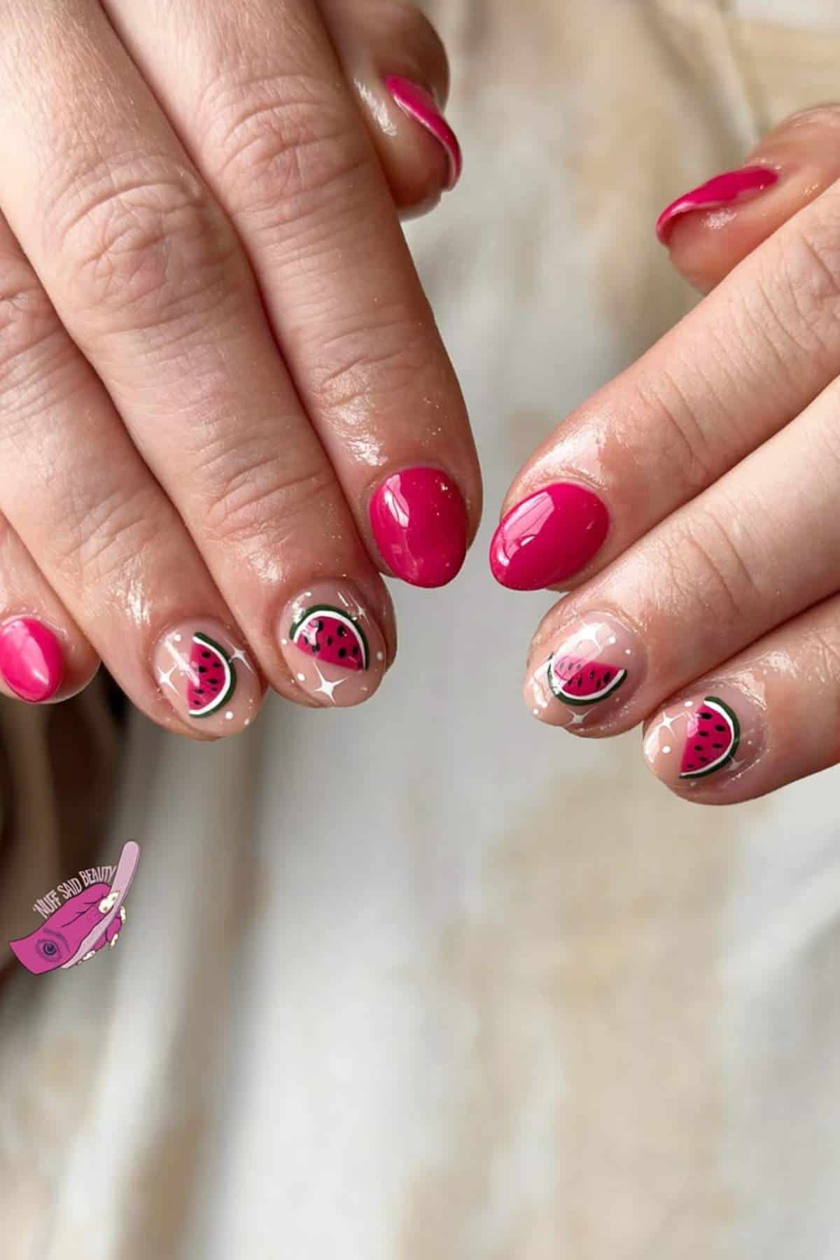 Hands with short, glossy nails; some are painted pink, while others have nude polish with watermelon slice nail art designs.