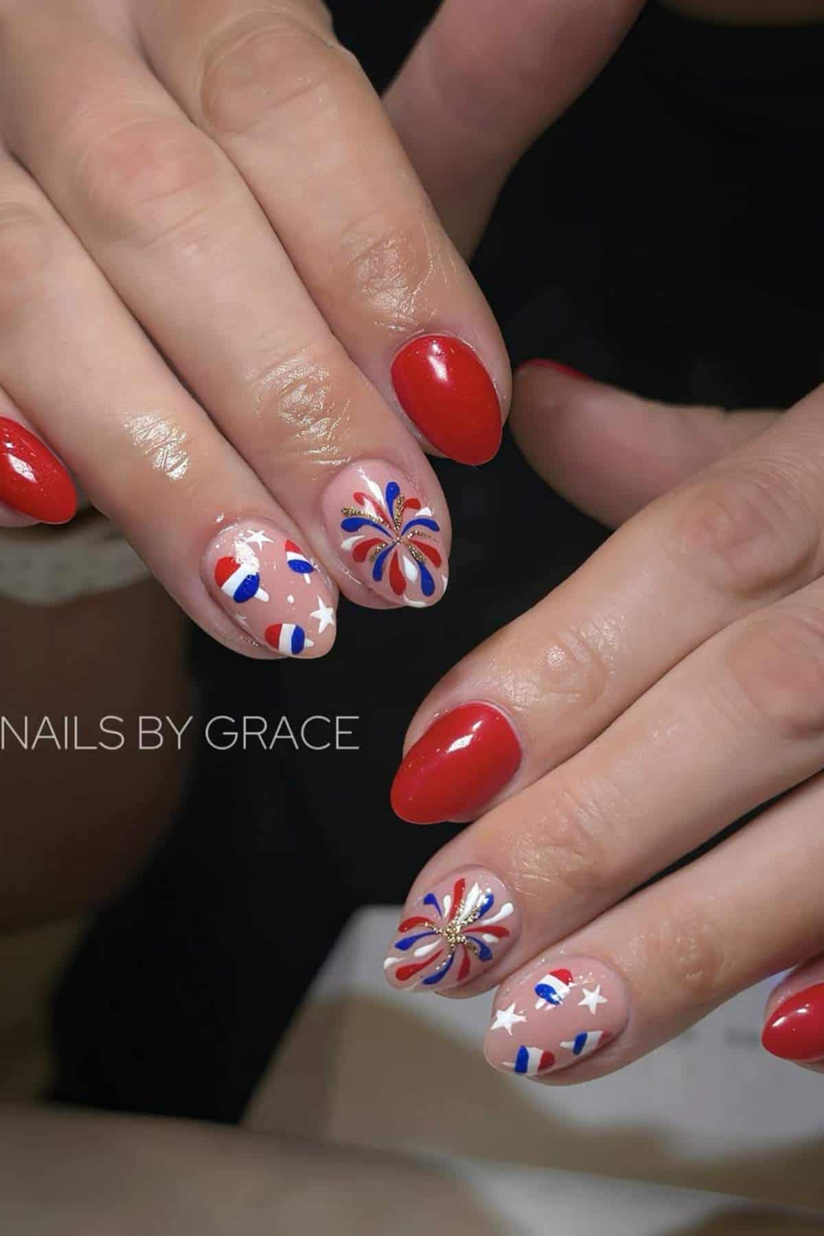 Red, white, and blue patriotic nail art with fireworks and stars.