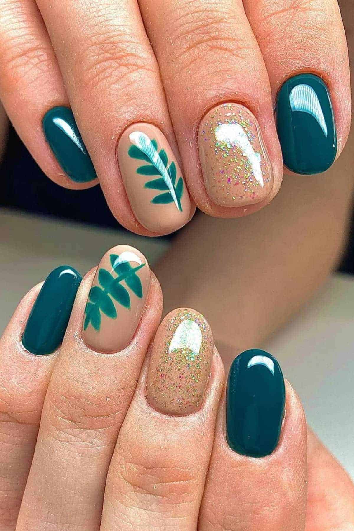 Hands with manicured nails featuring teal polish, glittery nude polish, and nude nails with teal leaf designs.