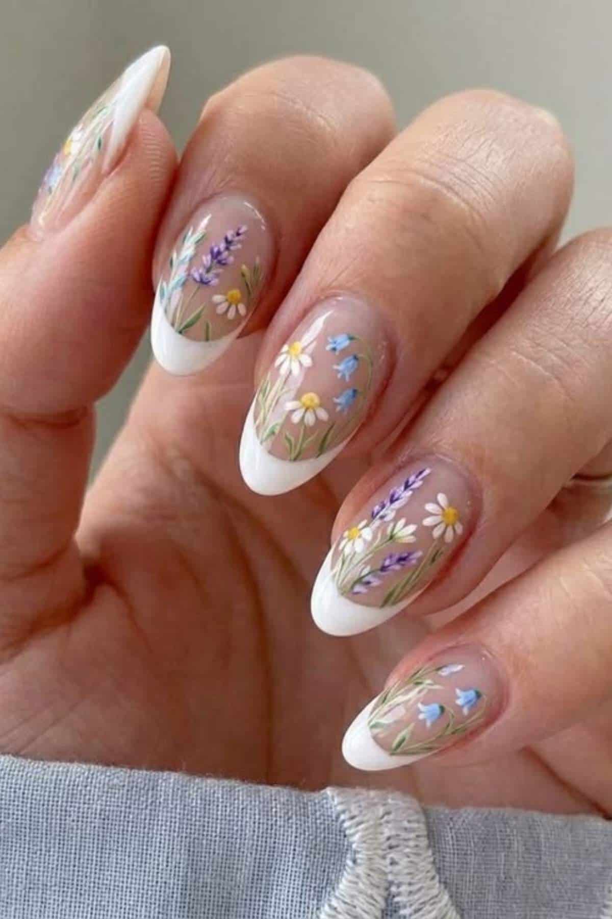 French tip nails with hand-painted wildflowers, including daisies, lavender, and bluebells.