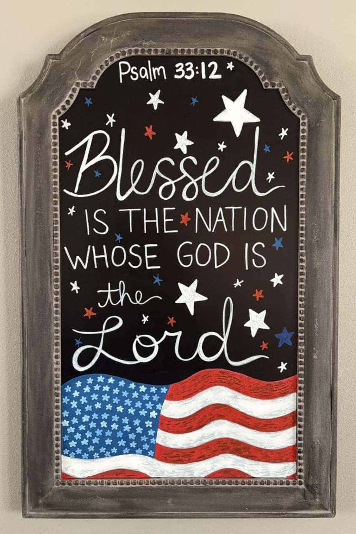A decorative sign displays Psalm 33:12 with stars and an American flag, reading “Blessed is the nation whose God is the Lord.”.