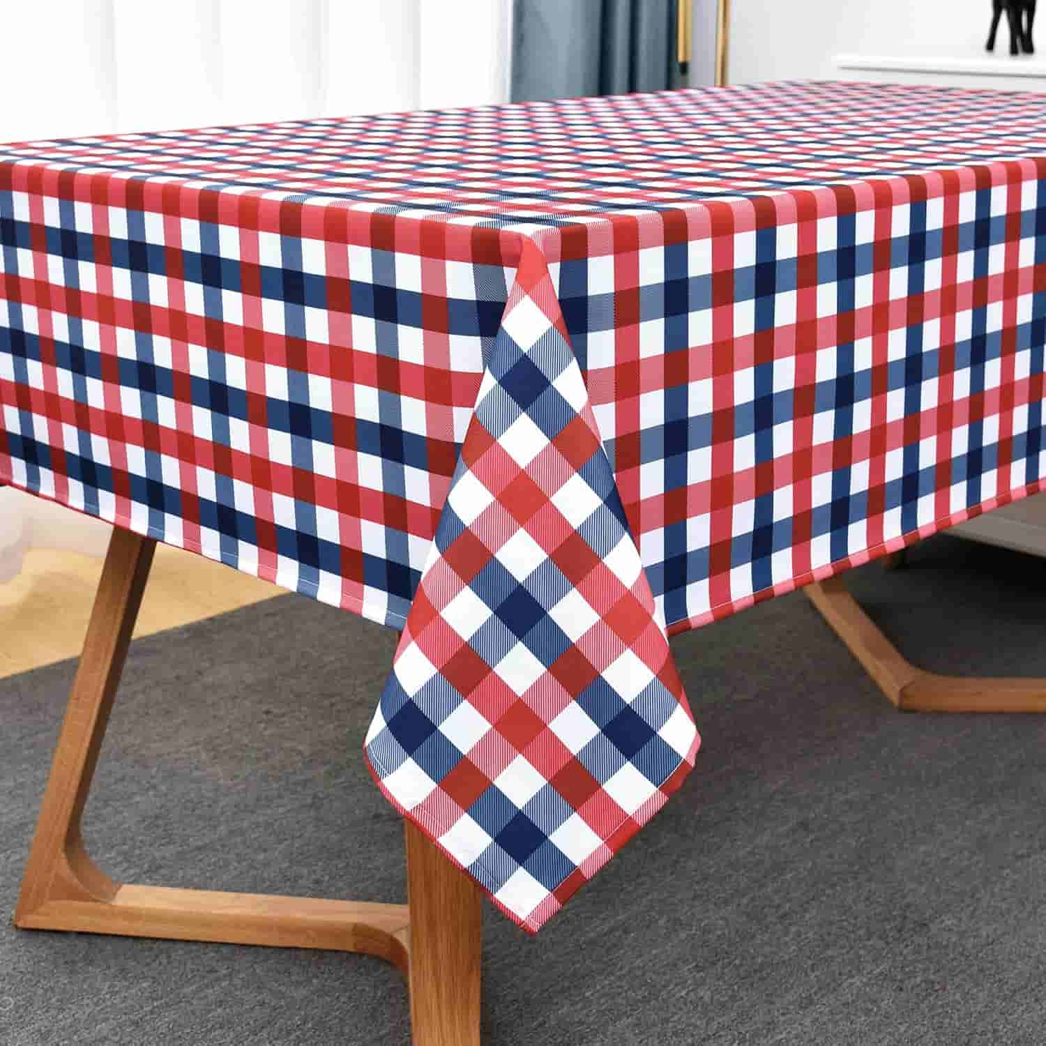 A rectangular table covered with a red, white, and blue checkered tablecloth. The table has wooden legs and is set on a dark carpeted floor.