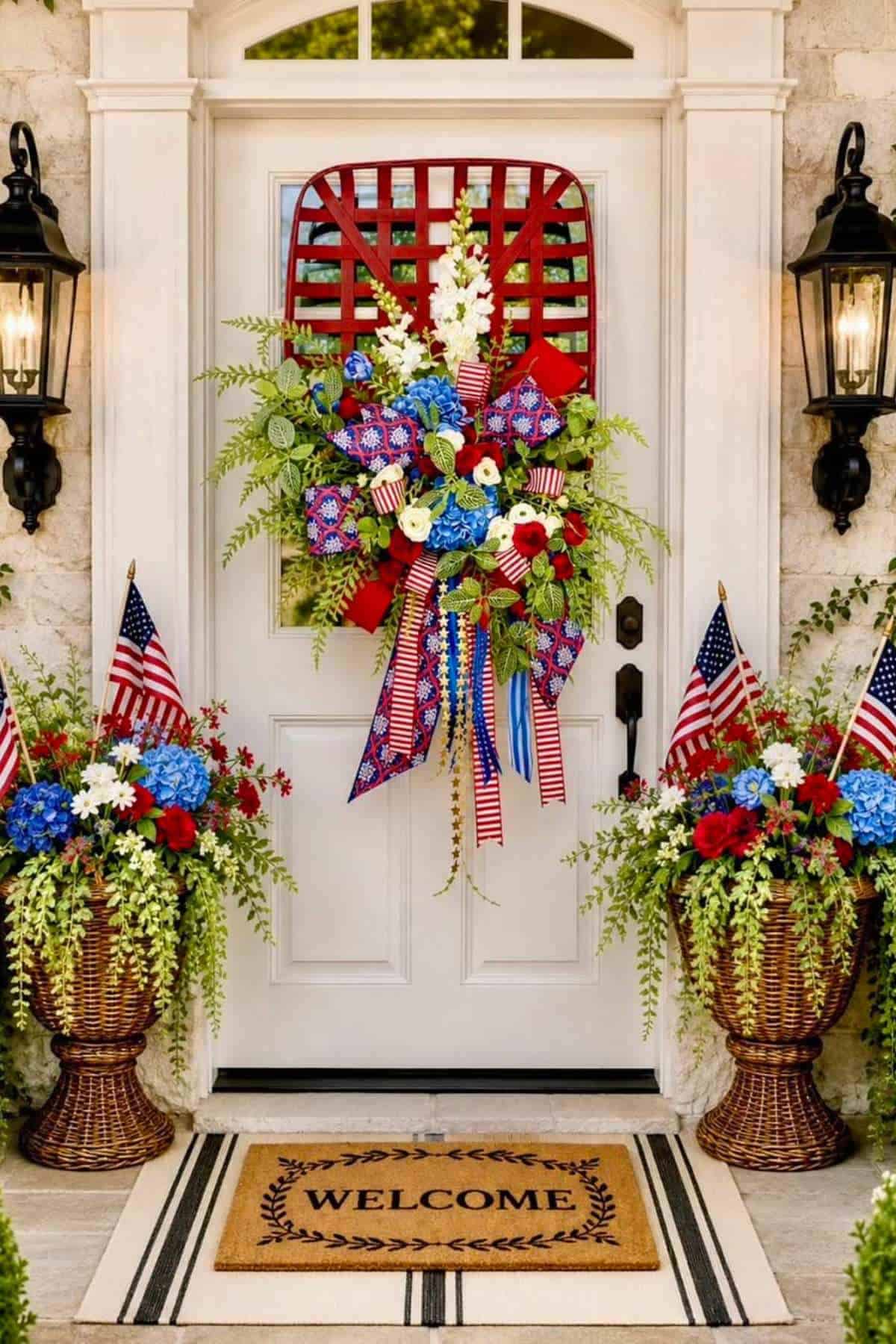 A white front door is decorated with a patriotic wreath and floral arrangements flanking the entrance.