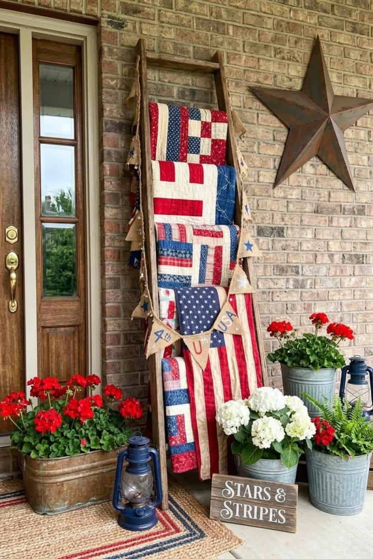 Patriotic decor on a porch with quilts, flags, lanterns, and plants.