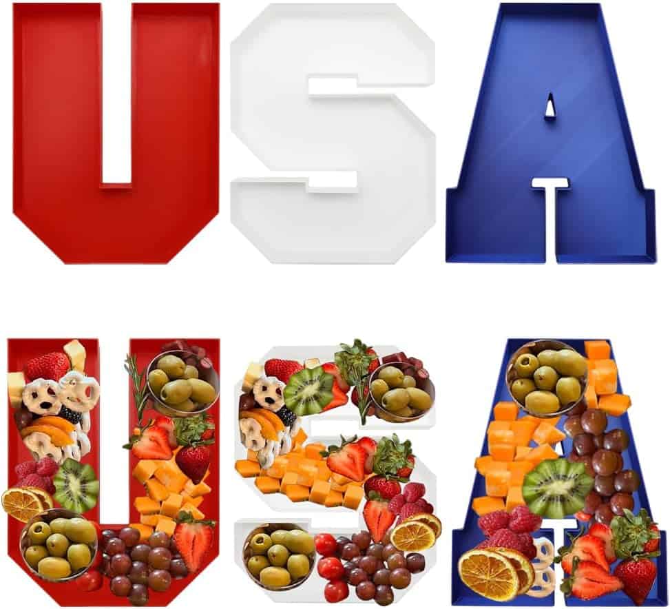 Three trays shaped like the letters U, S, and A, colored red, white, and blue on top, and filled with assorted fruits and snacks on the bottom.
