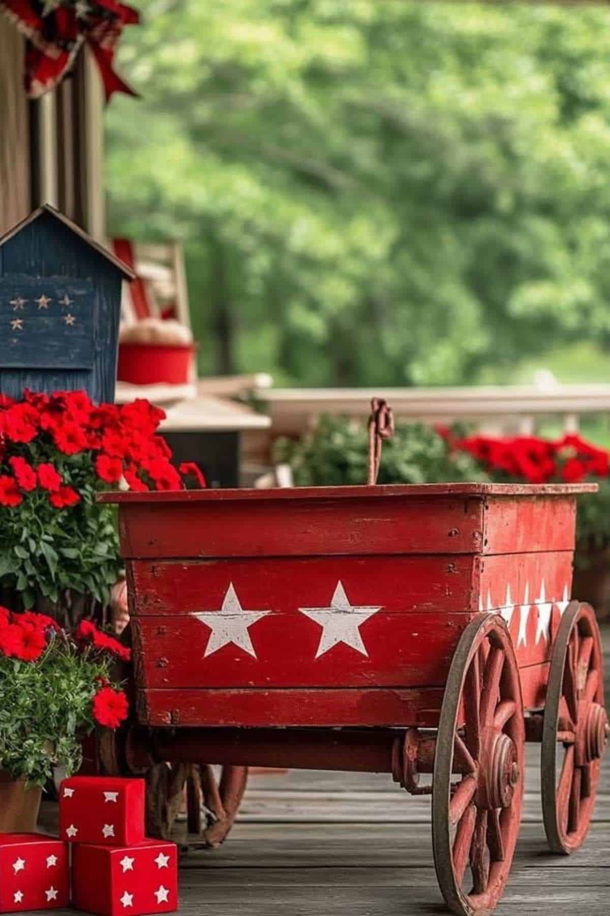 Red wooden wagon with white stars and red flowers on a porch.