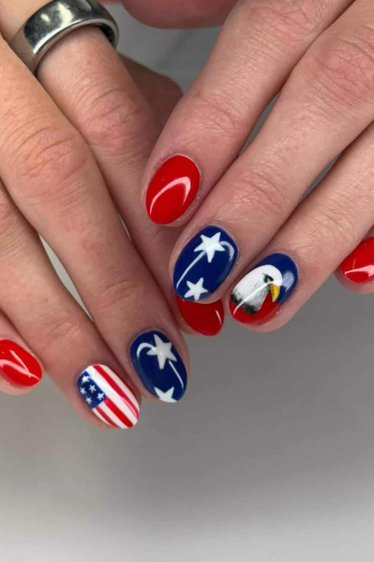 Hands with manicured nails featuring patriotic designs, including red, white, and blue colors, stars, the American flag, and a bald eagle.