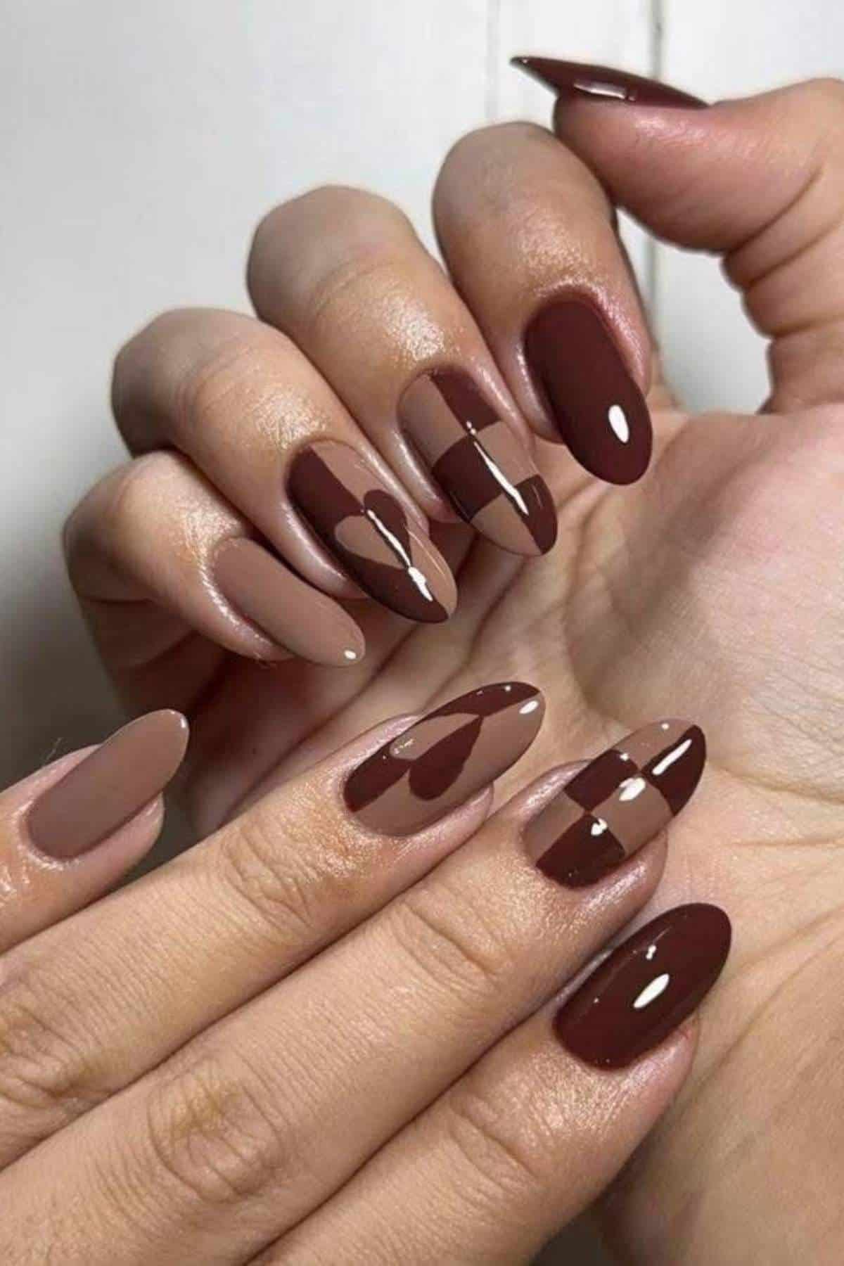 Two hands with almond-shaped nails painted in glossy shades of brown, featuring a mix of solid and half-and-half color block designs.