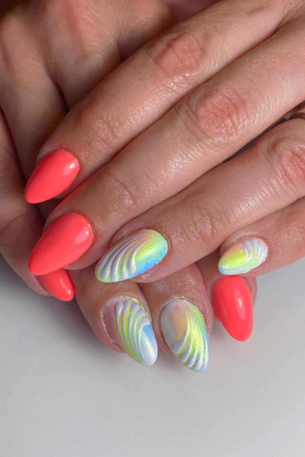 Hands with almond-shaped nails; some are painted bright coral, others have iridescent, shell-like 3D designs in pastel colors.