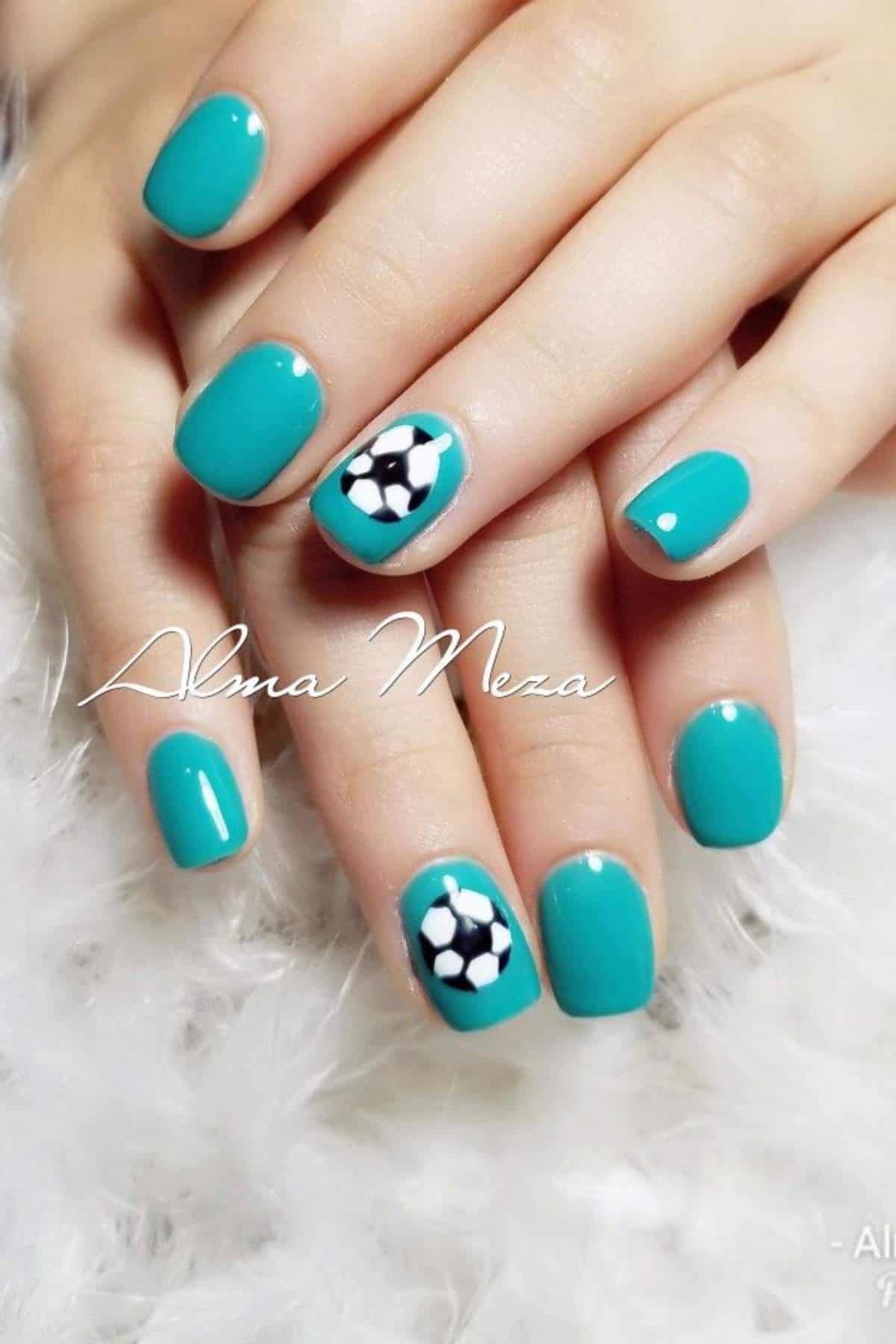 Hands with teal nail polish; one nail features a small soccer ball design and another has a single white dot accent.