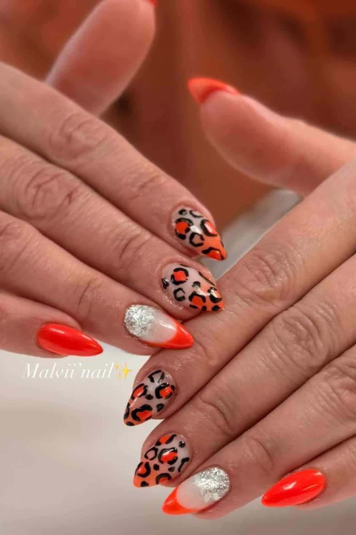 Hands with almond-shaped nails featuring red, silver glitter, and leopard print designs on a neutral background.