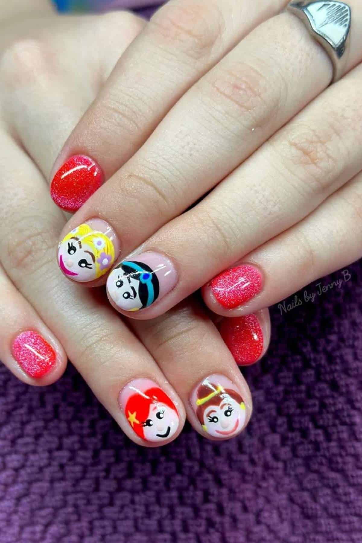 Hands with red glitter nail polish and cartoon faces of female superheroes painted on the fingernails, shown against a purple textured surface.
