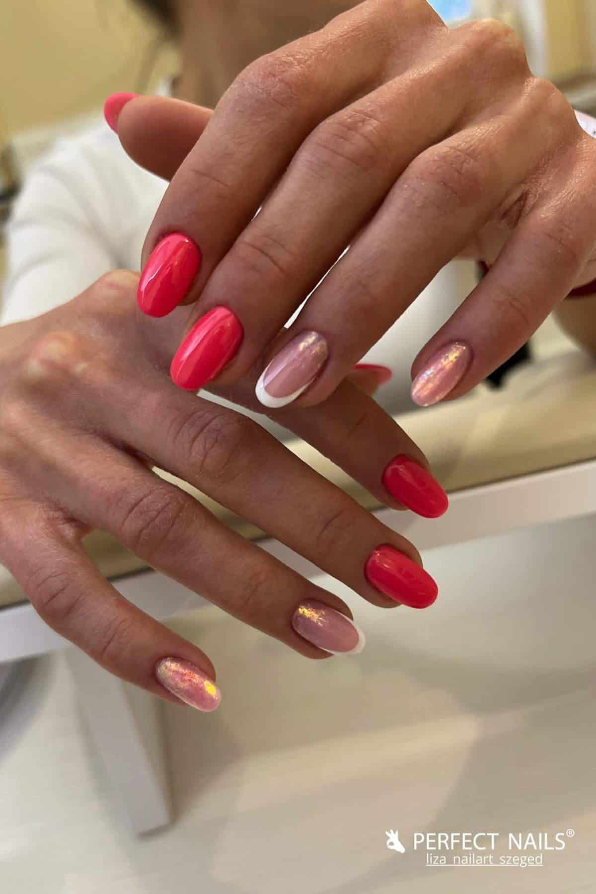 A person displays manicured nails with a mix of bright pink, pale pink, and iridescent finishes.