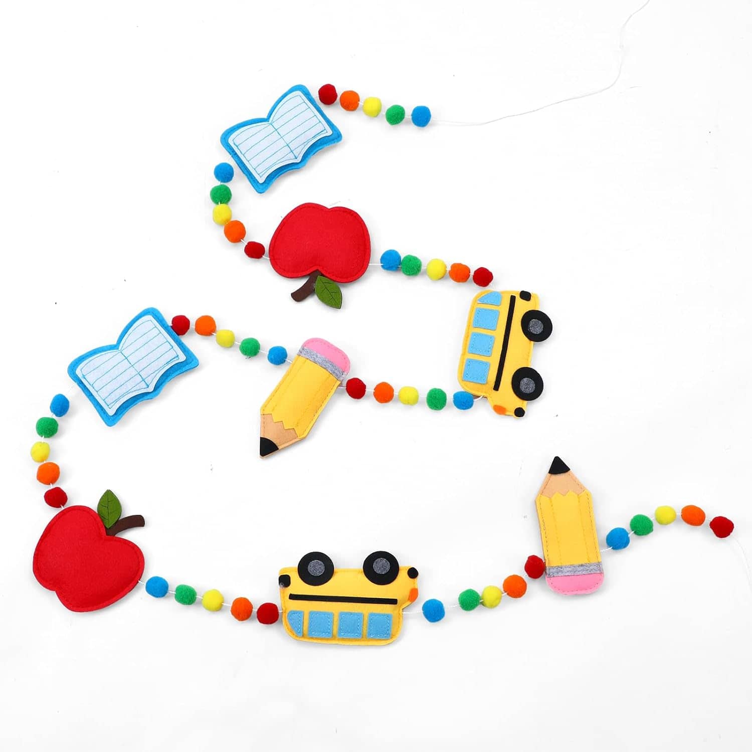 A colorful garland with felt shapes of apples, buses, pencils, books, and multicolored pom-poms on a white background.