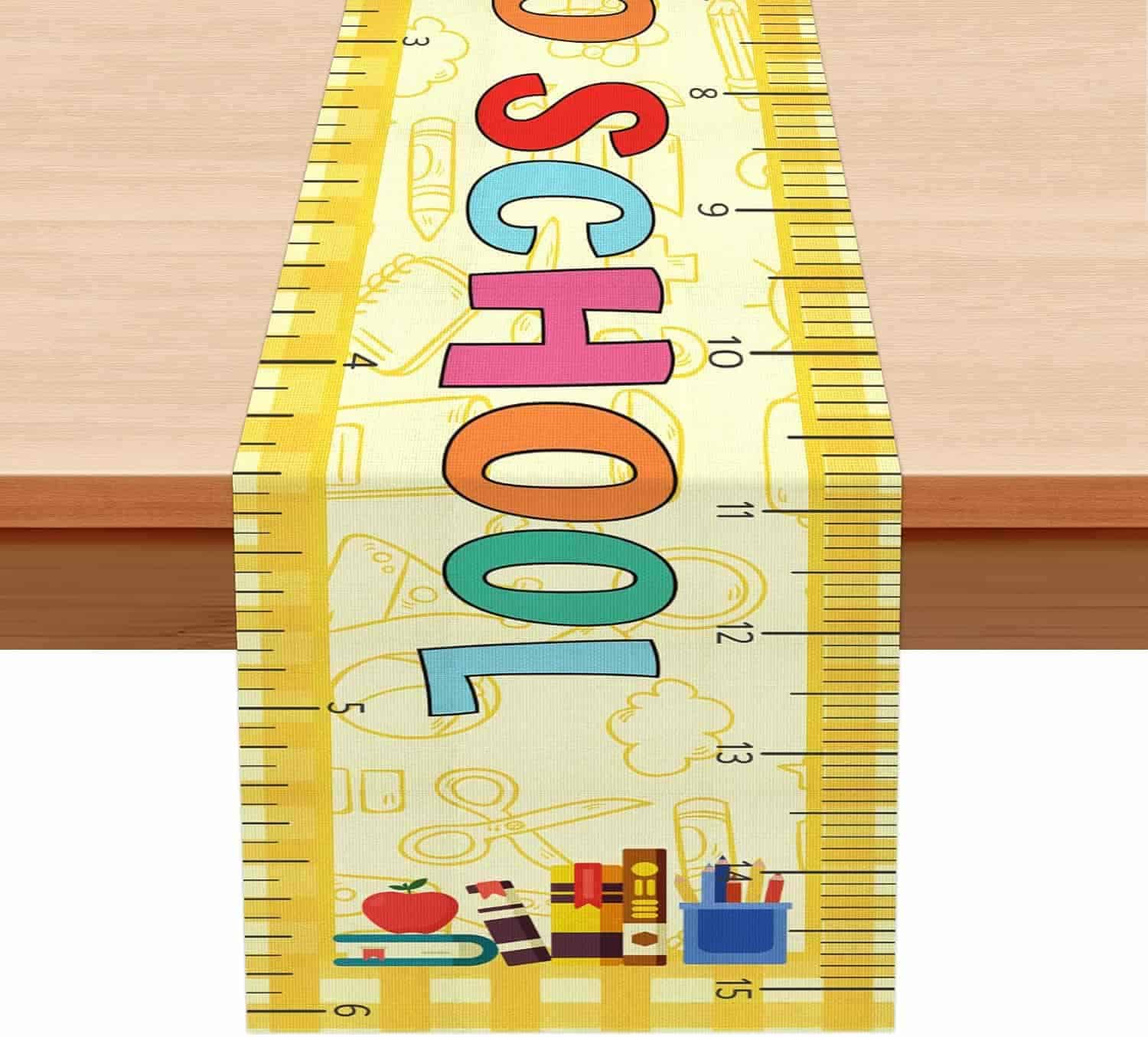 A table runner with a yellow ruler design, colorful letters spelling "SCHOOL," and school-themed illustrations and supplies at the bottom.