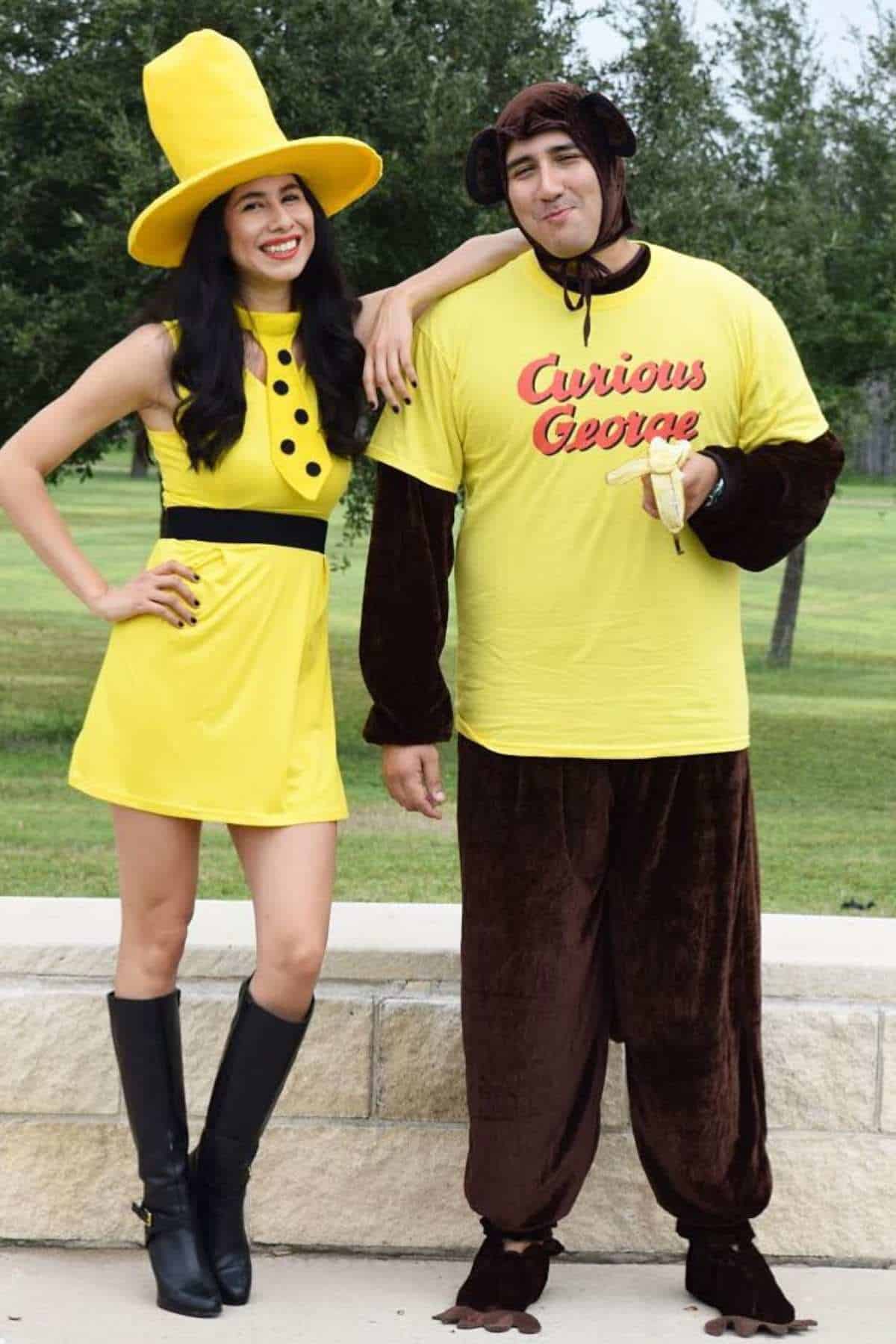 Two adults in costumes: one dressed as the Man with the Yellow Hat in a yellow dress and hat, the other as Curious George in a yellow shirt and brown monkey suit, standing outdoors.