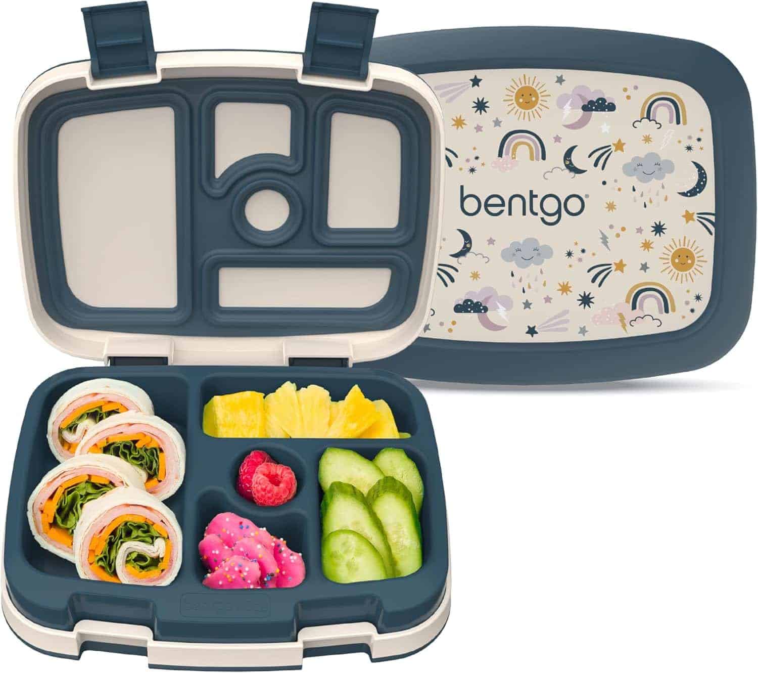 A Bentgo lunchbox with five compartments, containing rolled wraps, pineapple, raspberries, pink snack, and cucumber slices; the lid features a rainbow and cloud pattern.