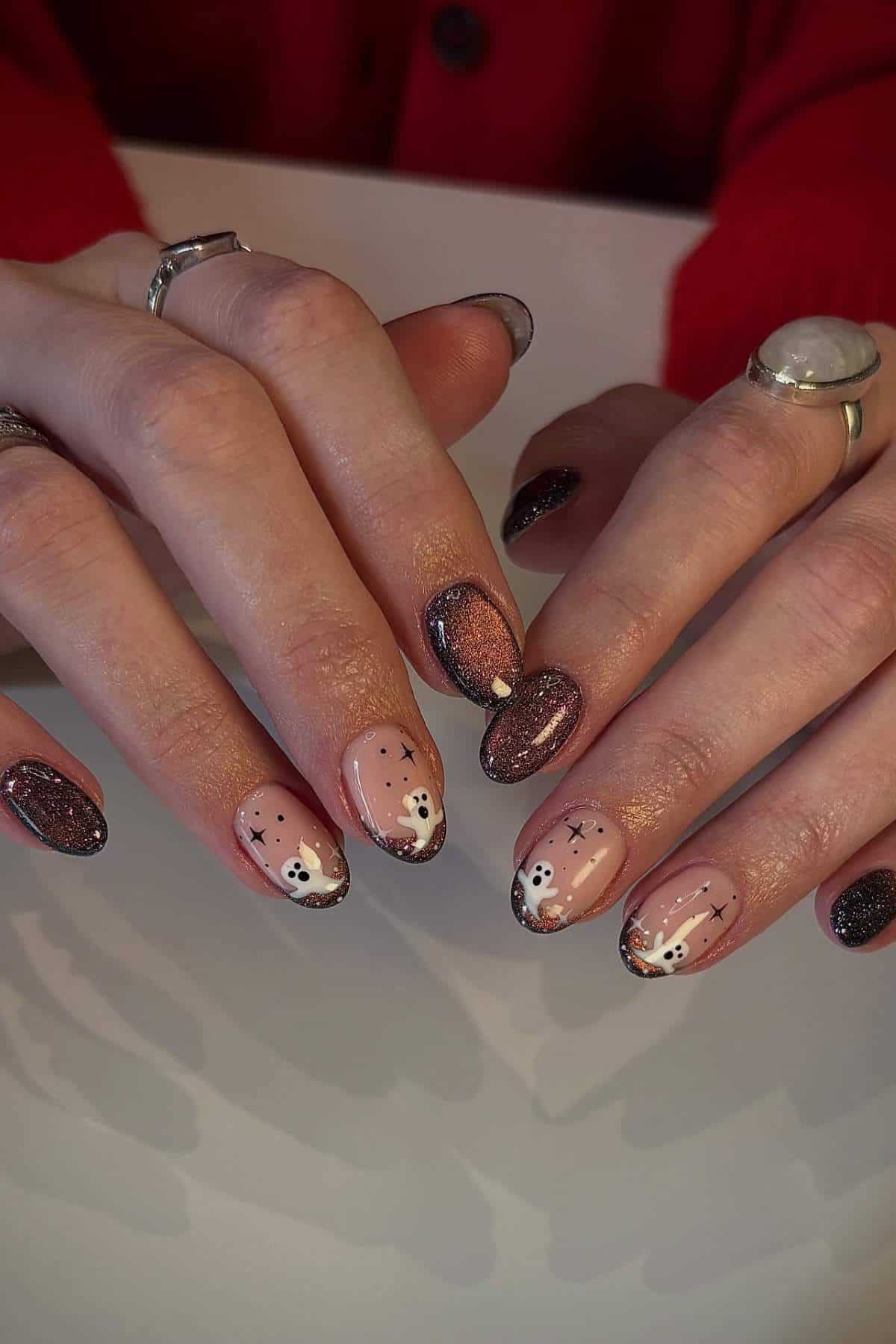 Hands with almond-shaped nails featuring brown glitter polish and bear face nail art on nude backgrounds.