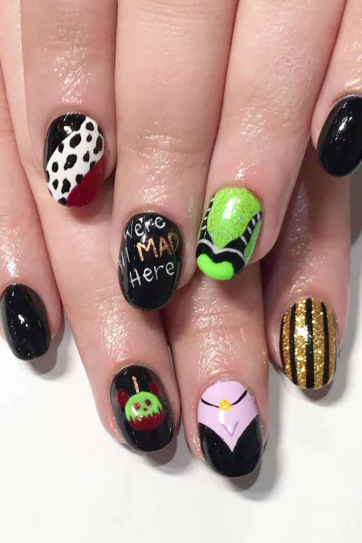 A hand with nails painted in various Disney villain designs, including black, green, gold stripes, dalmatian spots, and text reading "We're all MAD here.