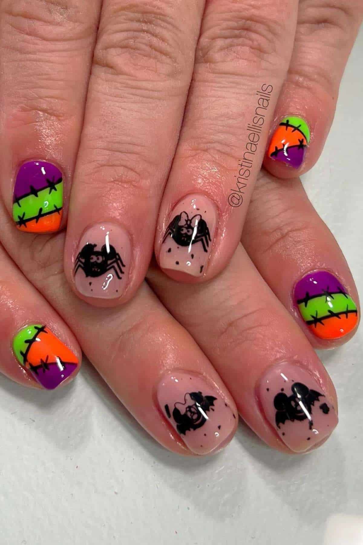 Fingernails with Halloween designs: spiders and bats on nude polish, and bright orange, purple, and green nails with black barbed wire patterns.