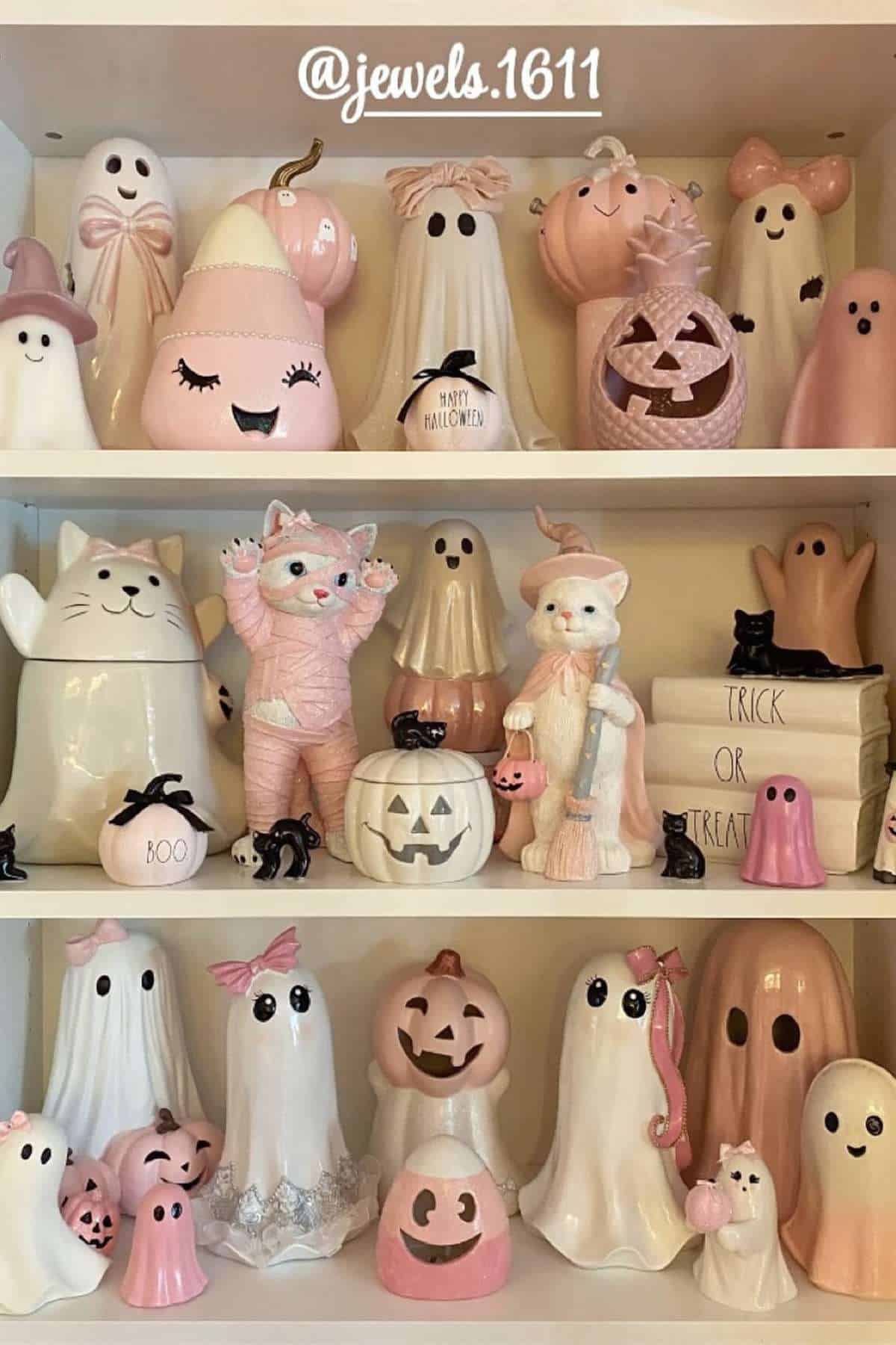 Shelves display various pastel pink and white Halloween decorations, including ghosts, pumpkins, cats, and bats, with some items featuring smiling faces.