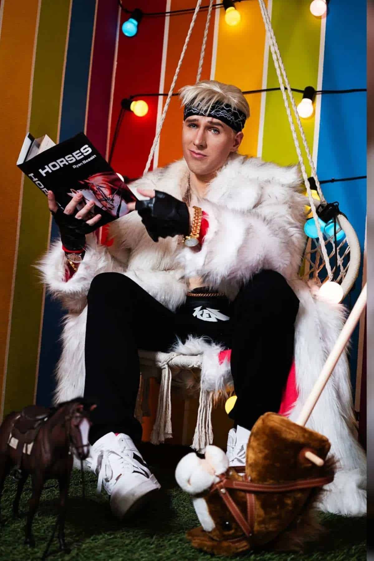 Person in a white fur coat sits on a swing chair, holding a book titled “HORSES,” with toy horses on the ground and colorful lights and striped background behind them.