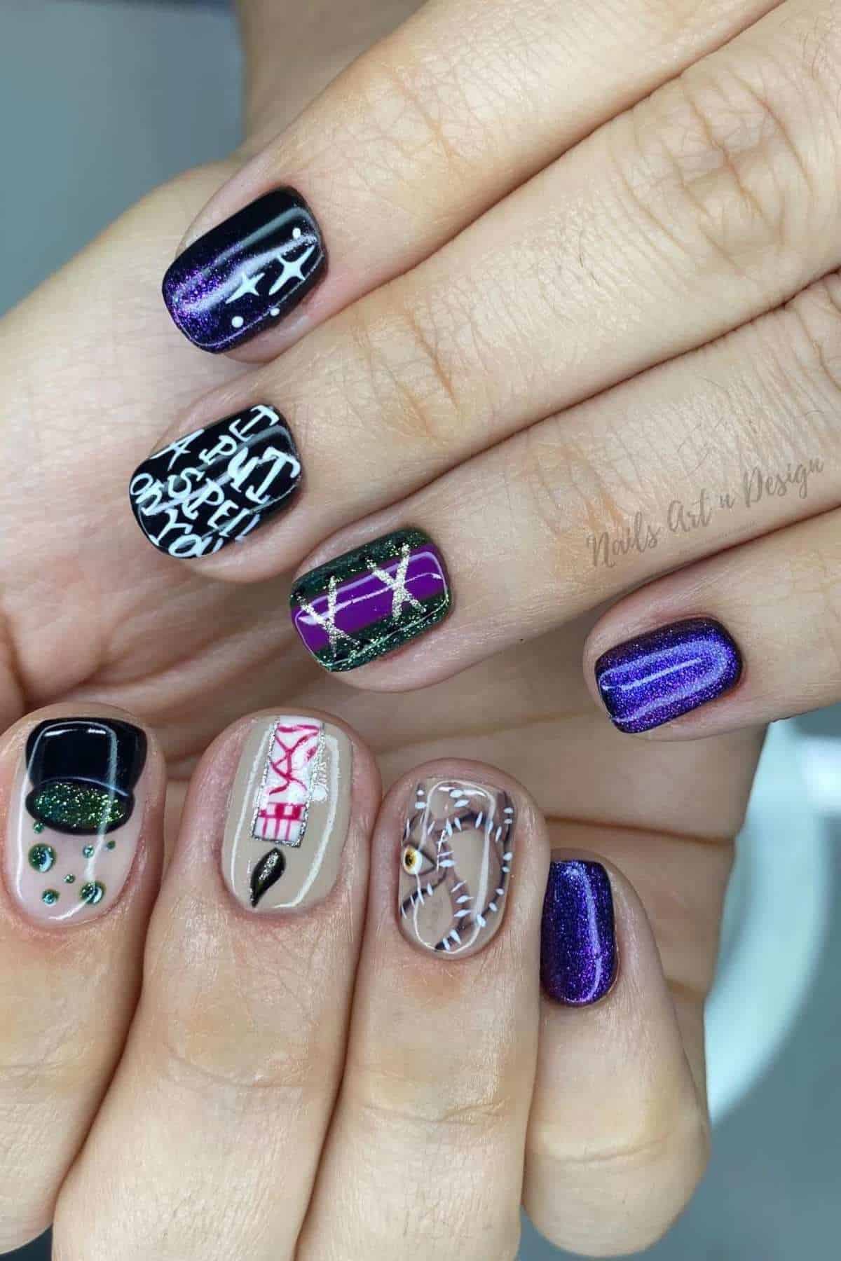 Ten fingernails with Halloween-themed nail art, including spider webs, a mummy, a stitched mouth, and black, purple, and green designs with accents and lettering.