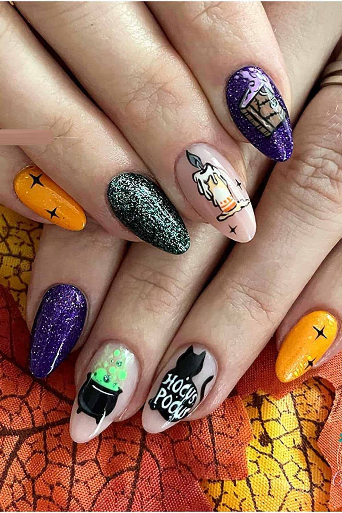 Hands with Halloween-themed nail art featuring candles, cauldron, potion bottles, “Hocus Pocus” text, stars, and glitter in orange, purple, black, and green on almond-shaped nails.