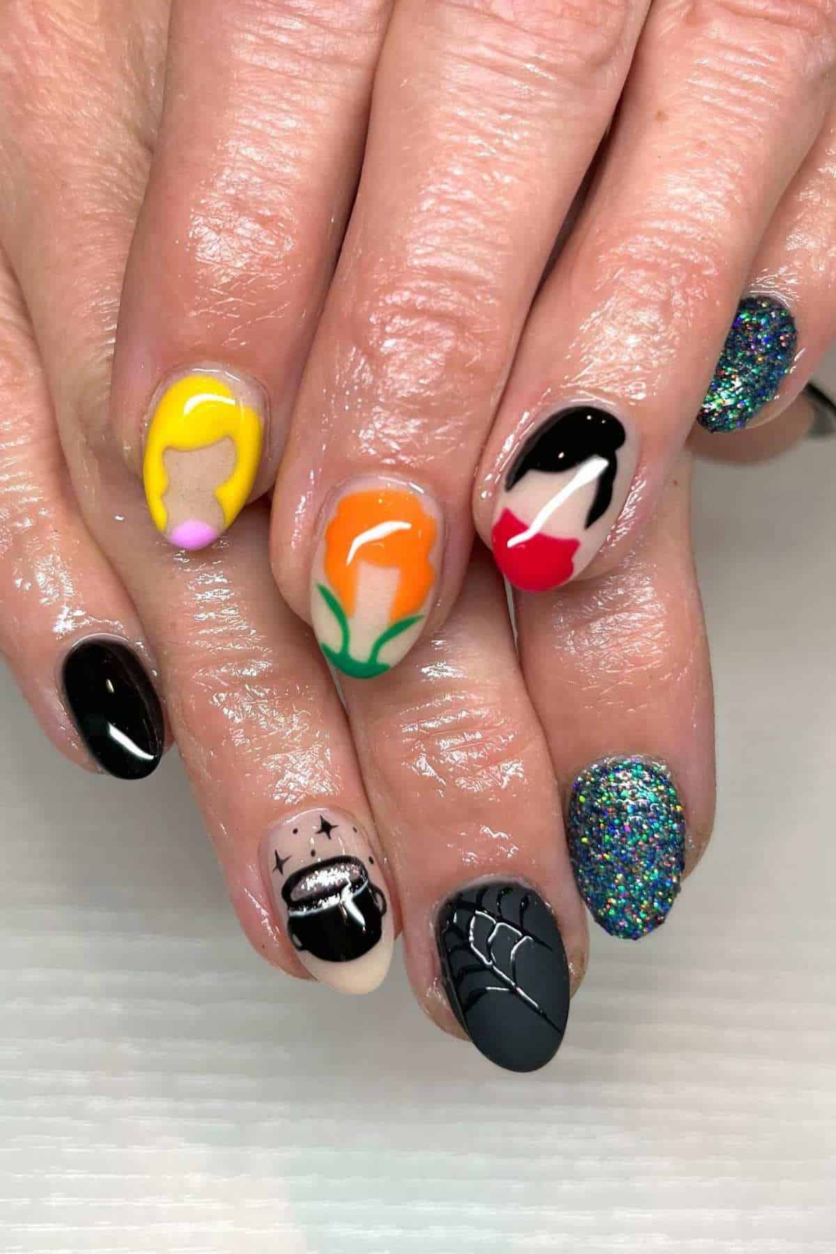 Fingernails with colorful art including simple portraits, glitter, spiderweb, and a black cauldron.