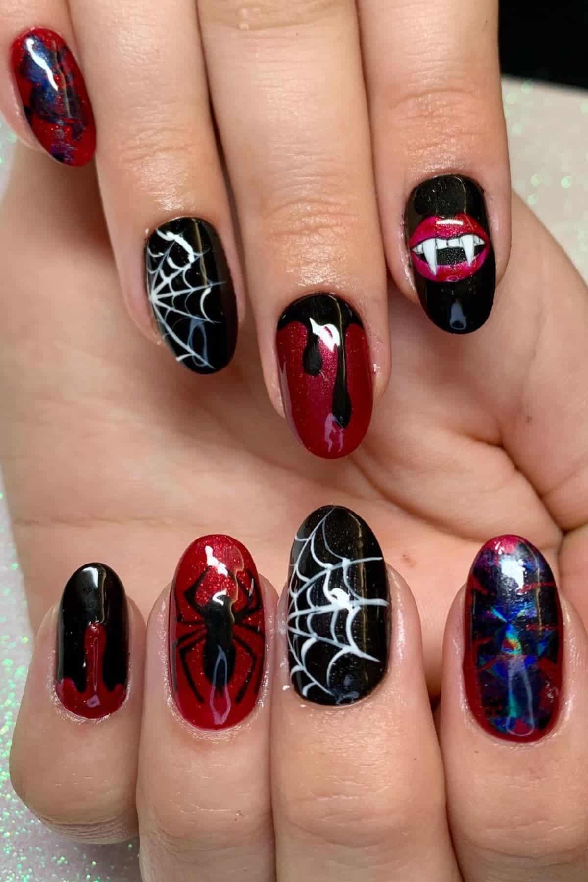 Hand with long, painted fingernails featuring Spider-Man, spider webs, vampire fangs, dripping blood, and dark, red and black color themes.