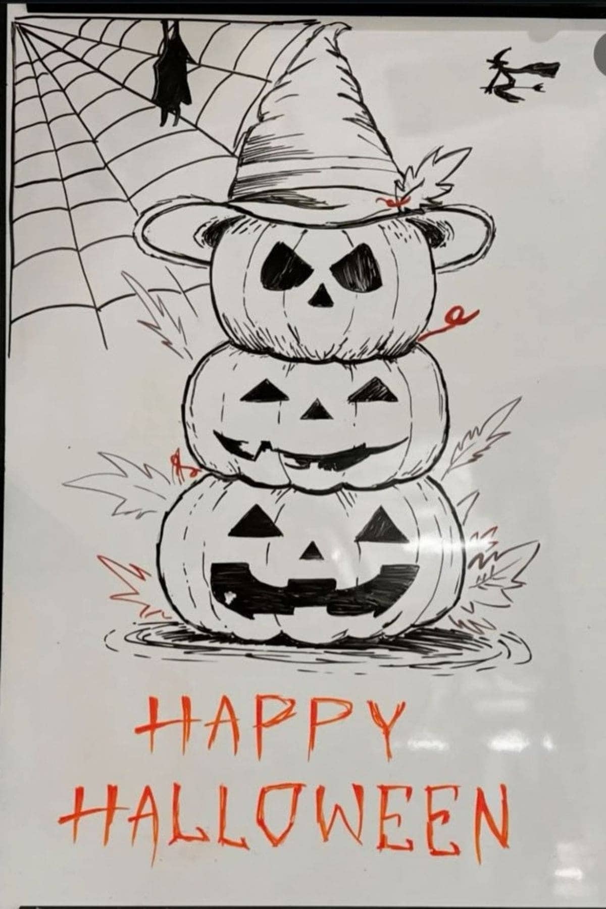 Three stacked jack-o’-lanterns with a witch hat, spider web, bat, and flying witch. “HAPPY HALLOWEEN” is written in orange below the pumpkins.