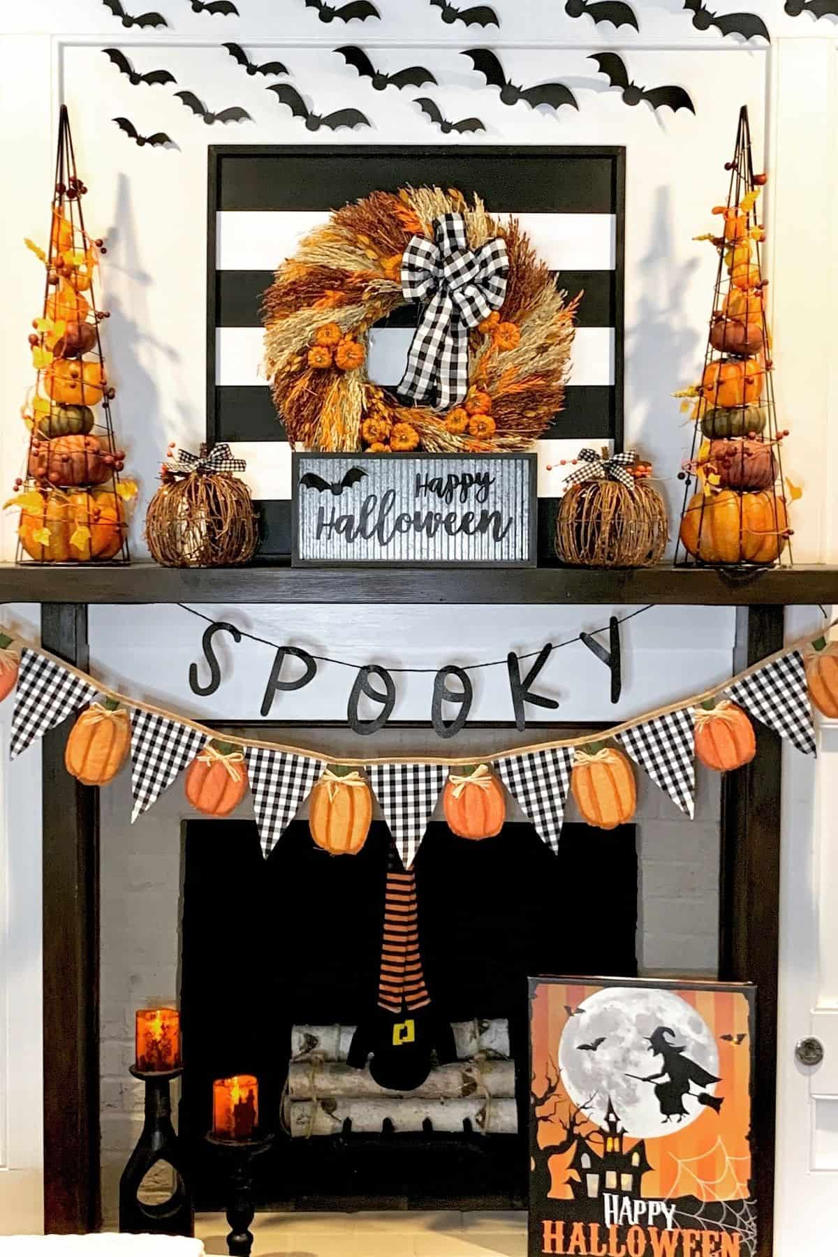A fireplace decorated with a “Spooky” banner, pumpkins, a Halloween wreath, bats on the wall, and “Happy Halloween” signs in black, orange, and white colors.