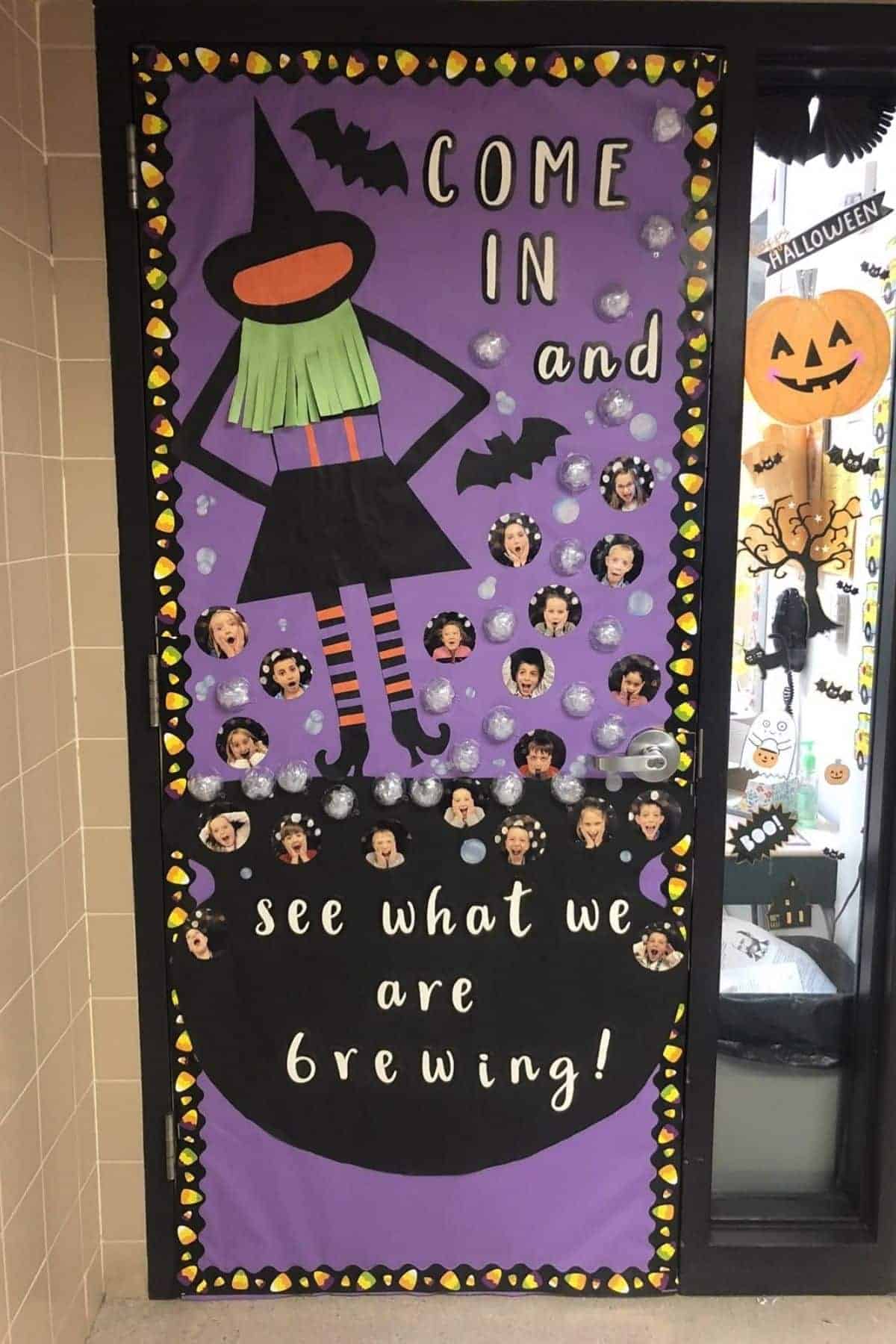 Classroom door decorated with a witch, bats, and cauldrons with students’ faces, reads: “Come in and see what we are brewing!” Halloween-themed display with purple background.