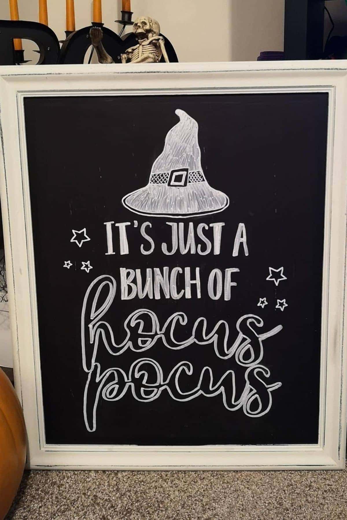 A chalkboard sign with a witch hat illustration reads, “It’s just a bunch of hocus pocus,” surrounded by stars.