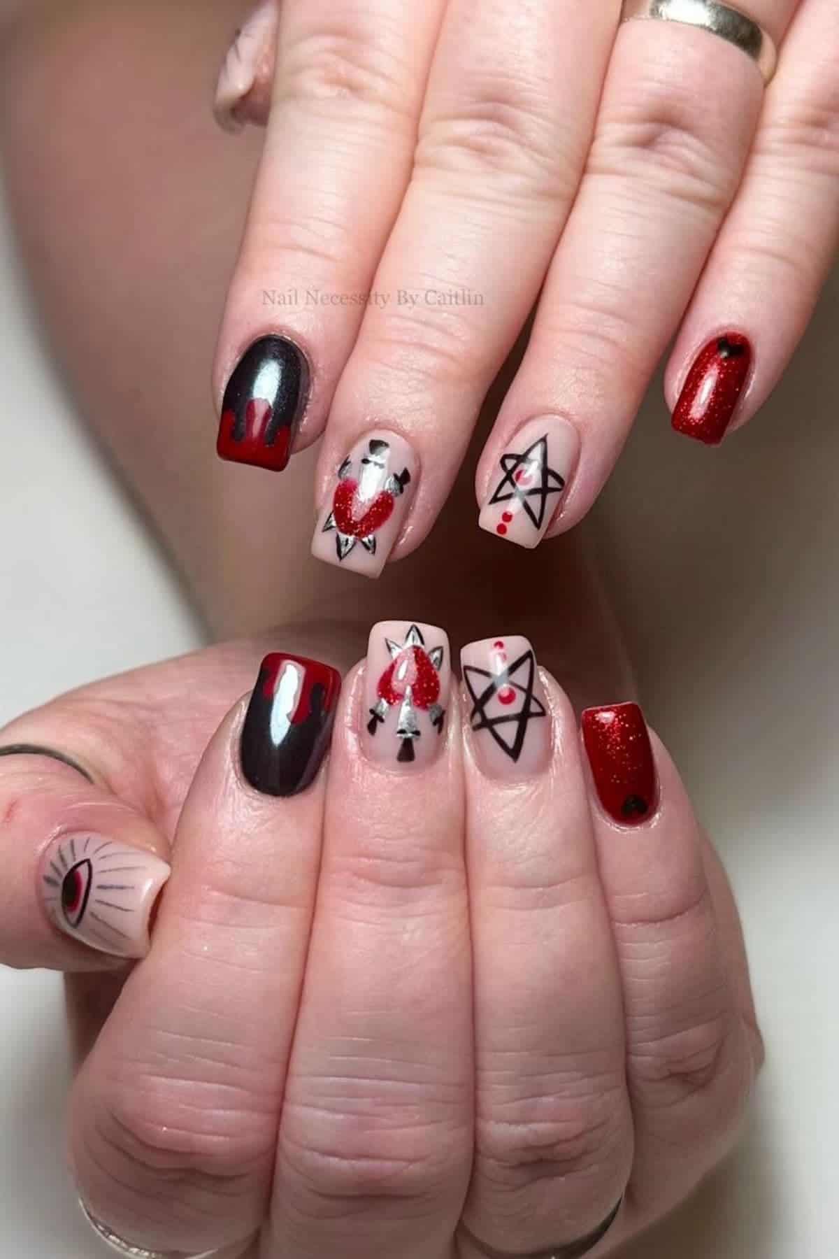 Hands with long square nails painted in red, black, and nude with designs including an eye, pentagrams, drips, and hearts. Some nails have shimmer or glitter accents.