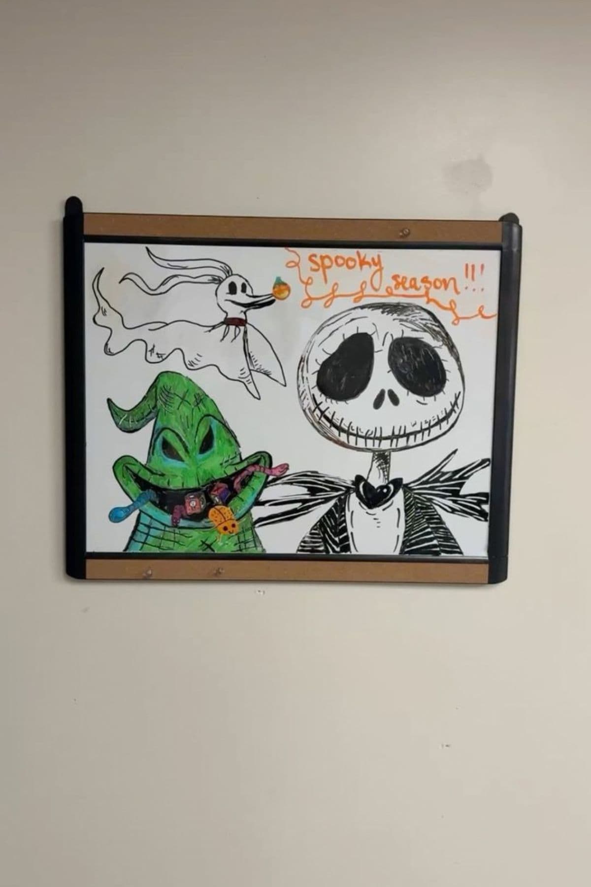 A dry-erase board features hand-drawn characters from “The Nightmare Before Christmas” and the text “spooky season!!!” written in orange marker.