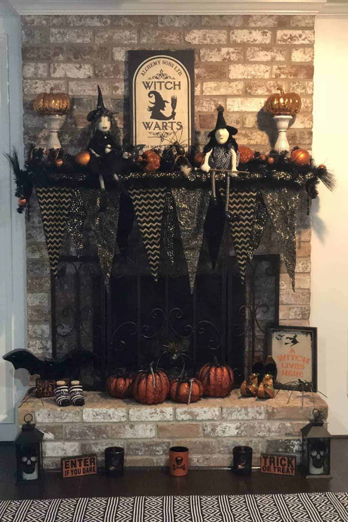 Brick fireplace decorated with Halloween items, including witches, pumpkins, black garland, banners, lanterns, and themed signs.