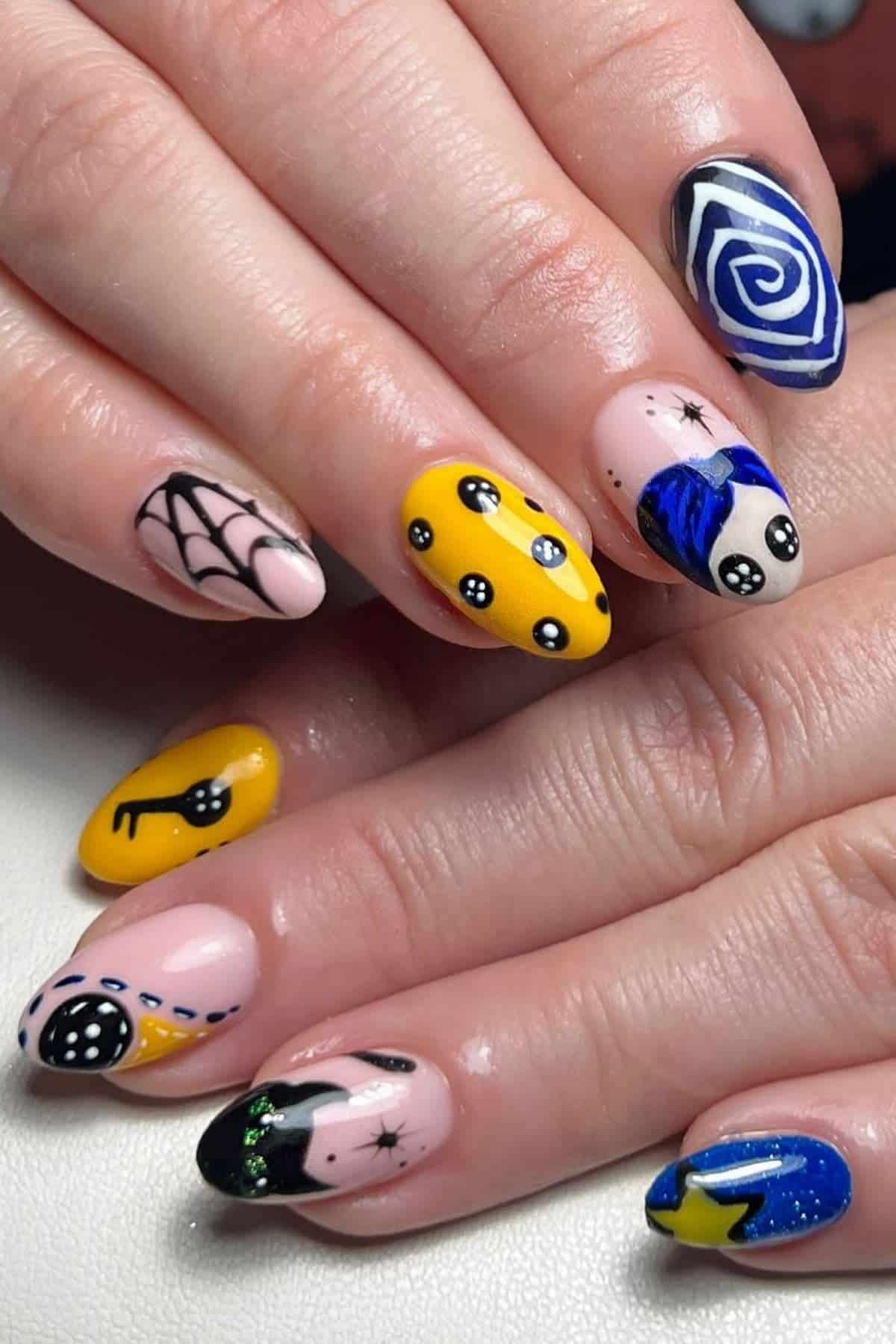 A hand with long nails features colorful, varied nail art designs including stars, eyes, a web, a spiral, and geometric shapes on a light pink base.