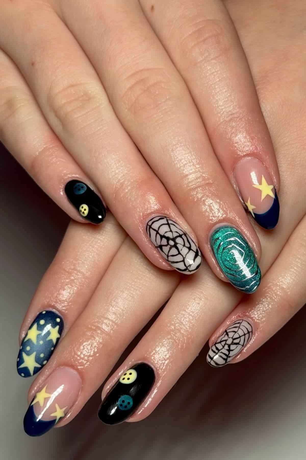 Hands with almond-shaped nails featuring designs of stars, smiley faces, spiderwebs, and a green swirl on a mix of black, navy, and natural-colored backgrounds.