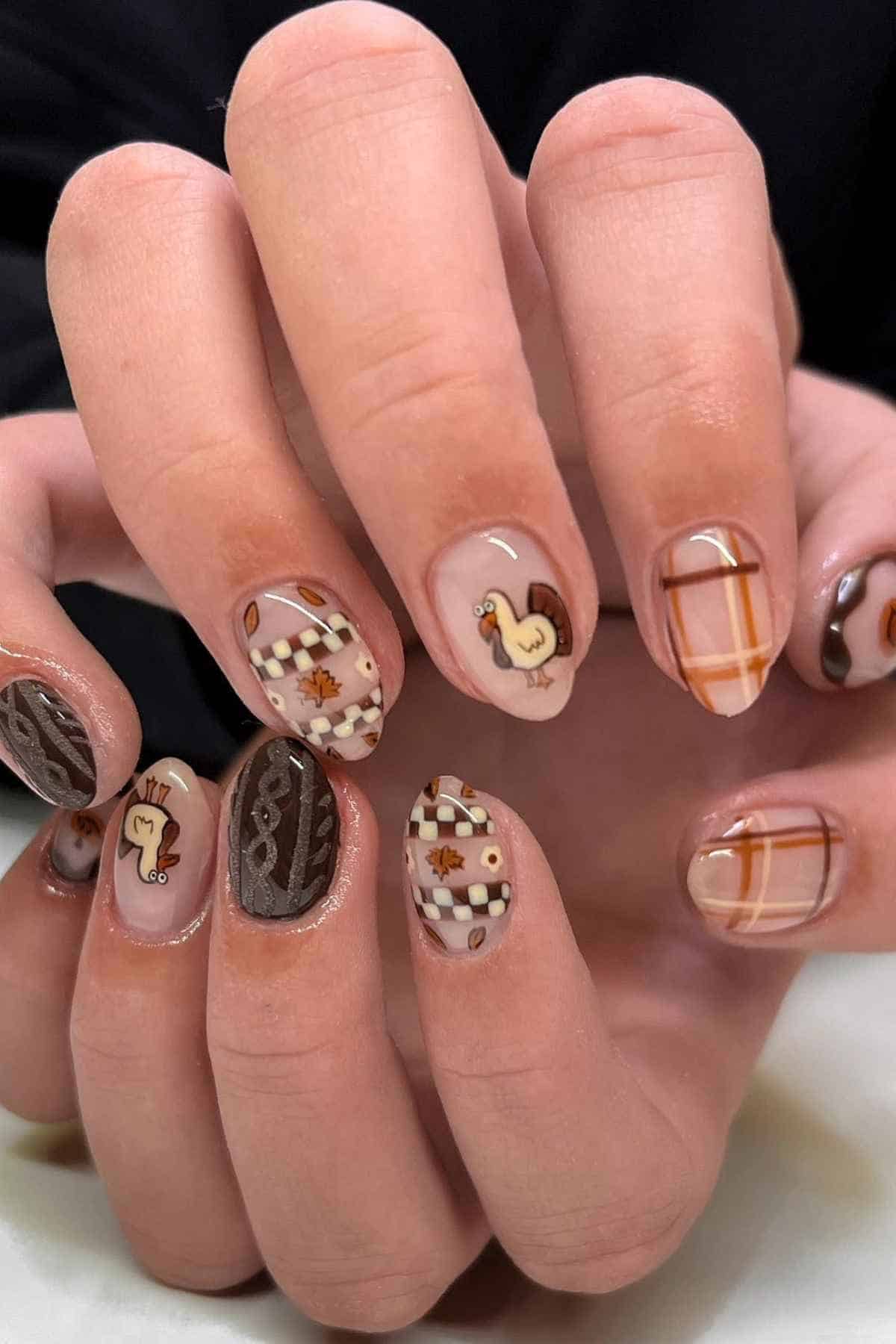 Manicured nails featuring Thanksgiving-themed nail art, including turkey illustrations, plaid patterns, cable knit textures, and autumn leaves.
