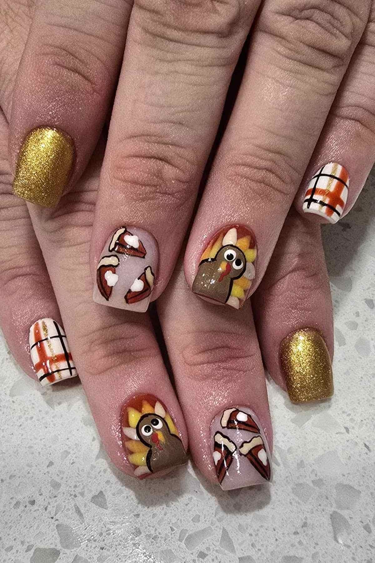 Fingernails painted with Thanksgiving-themed art including turkeys, pie slices, gold glitter, and a plaid pattern.