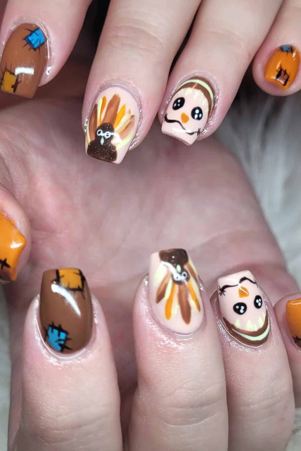 Manicure featuring Thanksgiving-themed nail art of turkeys, scarecrows, and brown patchwork designs.