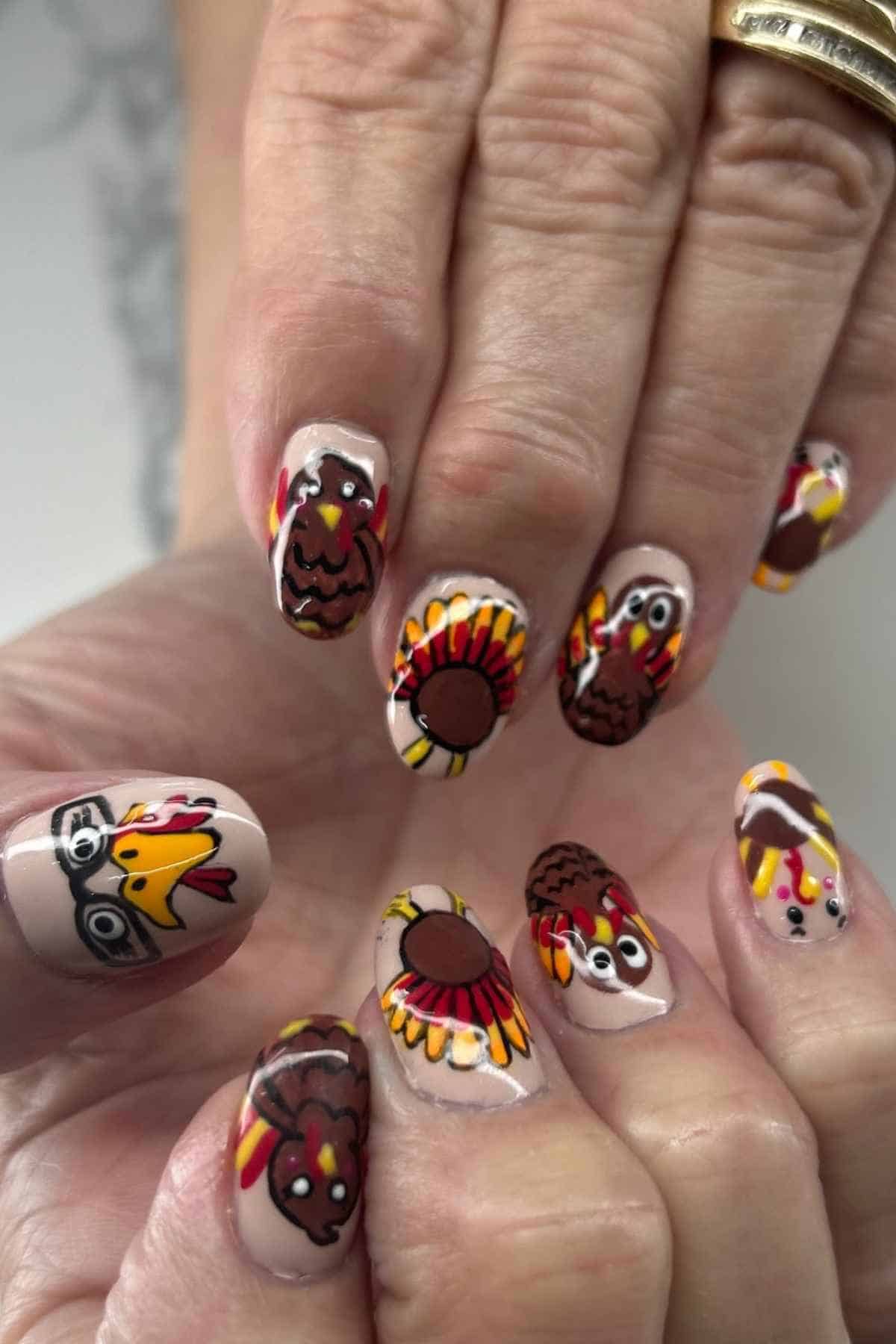 Fingernails painted with a Thanksgiving theme featuring turkeys and sunflowers.